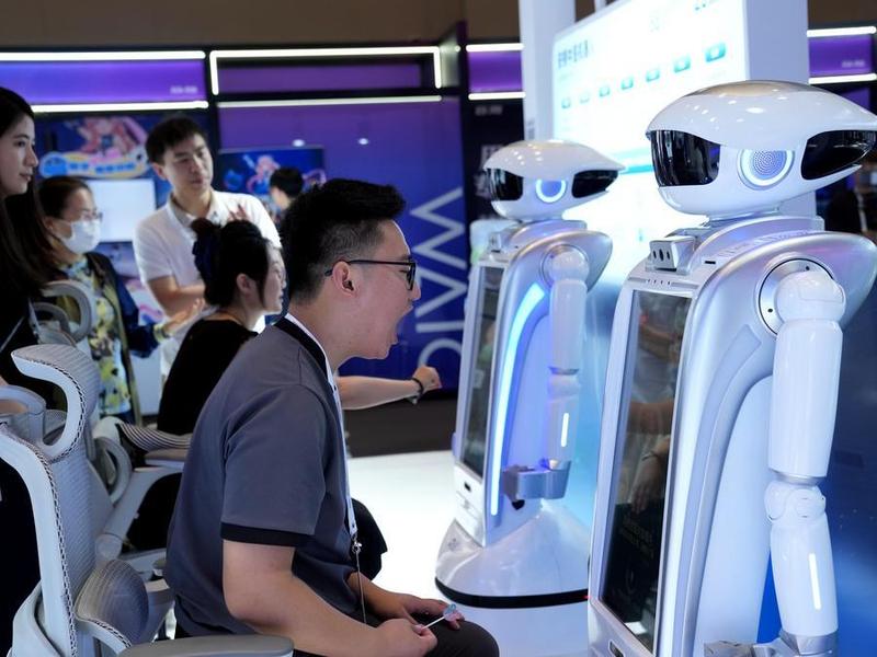 Visitors experience tongue diagnosis by TCM robots at the West Bund International Convention and Exhibition Center in Shanghai